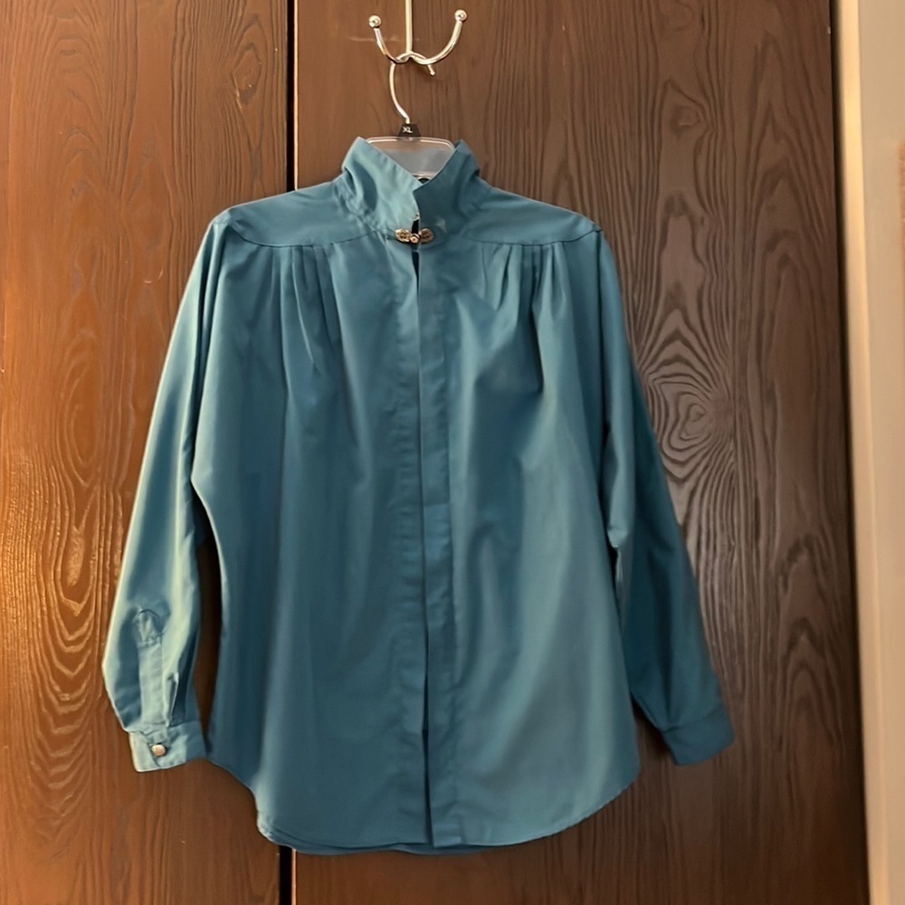 Cristina dark turquoise long sleeve blouse with unique closure at the neck. Med